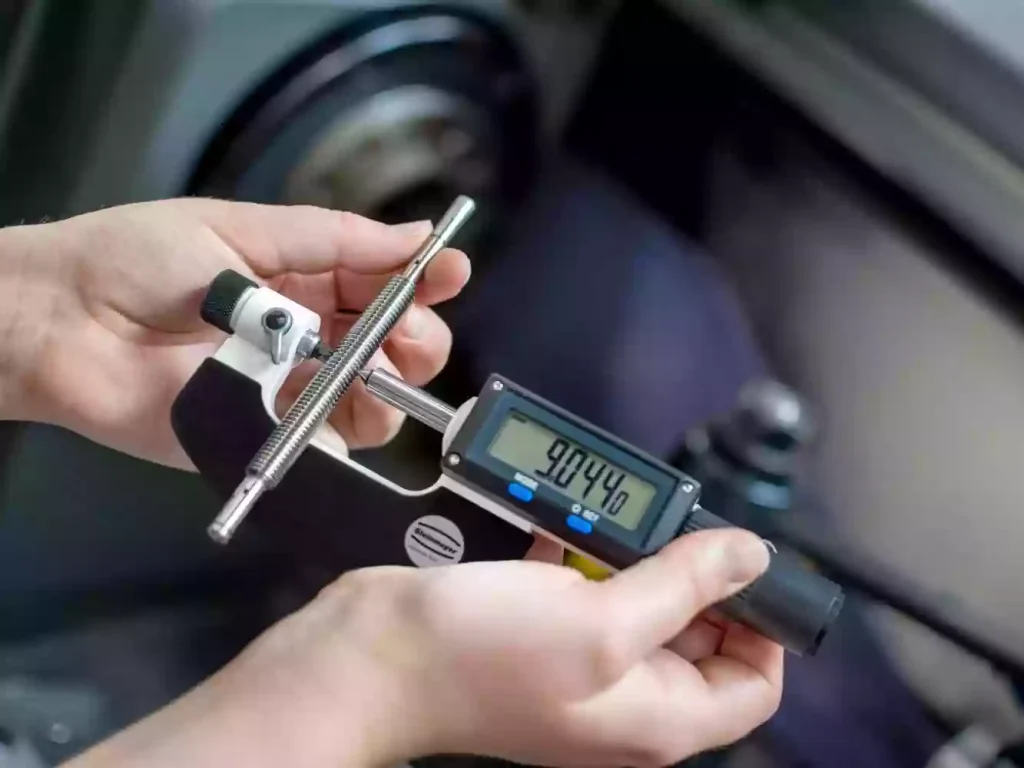 The Ultimate Guide to CNC Threading: Methods, Design Tips, and Troubleshooting 2 Quality inspector verifying the thread pitch and fit of a CNC-machined component using a precision thread ring gauge.