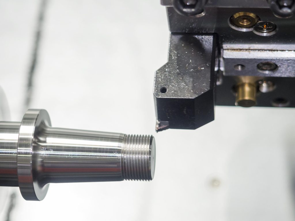Automotive Fasteners Explained: Types, Materials, Applications, and Manufacturing Considerations 3 CNC machining process for custom automotive fasteners, showing precision turning, thread machining, and inspection of metal components.